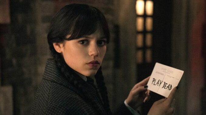 Wednesday addams holding a card in wednesday