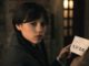 Wednesday addams holding a card in wednesday